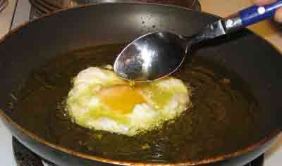 Basting greek recipe fried eggs with oil.
