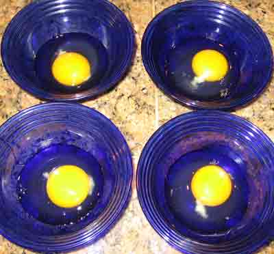 Cracking the eggs into bowls for Greek recipe for fried eggs.