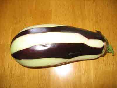 Eggplant with strips of skin peeled off.