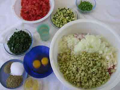 Adding more ingredients for greek recipe keftedes kalokairinoi summer meatballs.