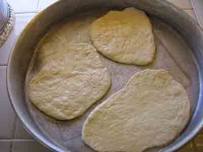 Flattened loaves on oiled pan to rise.