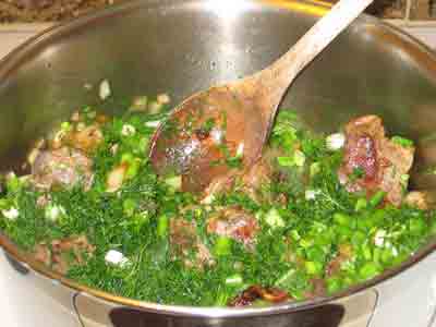 Adding dill and green onions to the browned lamb chops.