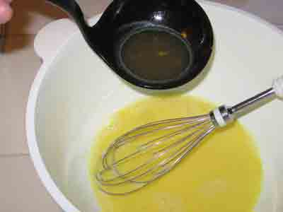 Adding hot liquid to the avgolemono.
