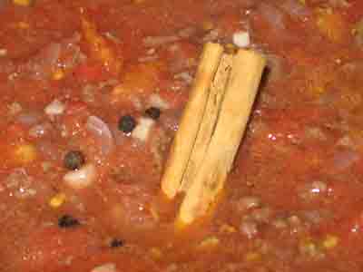 Add tomato sauce and spices to greek recipe makaronia me kima, greek spaghetti with meat sauce.