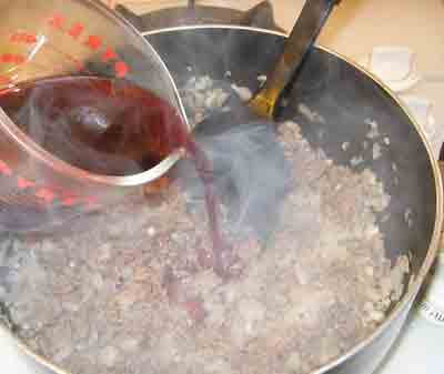 Adding wine to the greek recipe makaronia me kima, greek spaghetti with meat sauce