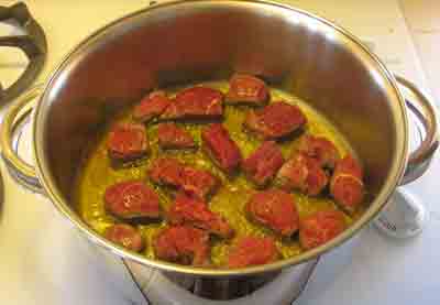 Add beef to hot oil for beef with artichokes moschari-me-agkinares