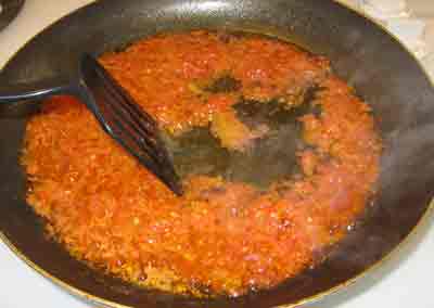 Keep stirring the tomatoes for the greek recipe strapatsada.