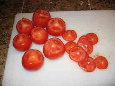 Tomatoes with their tops sliced off, ready to be grated.